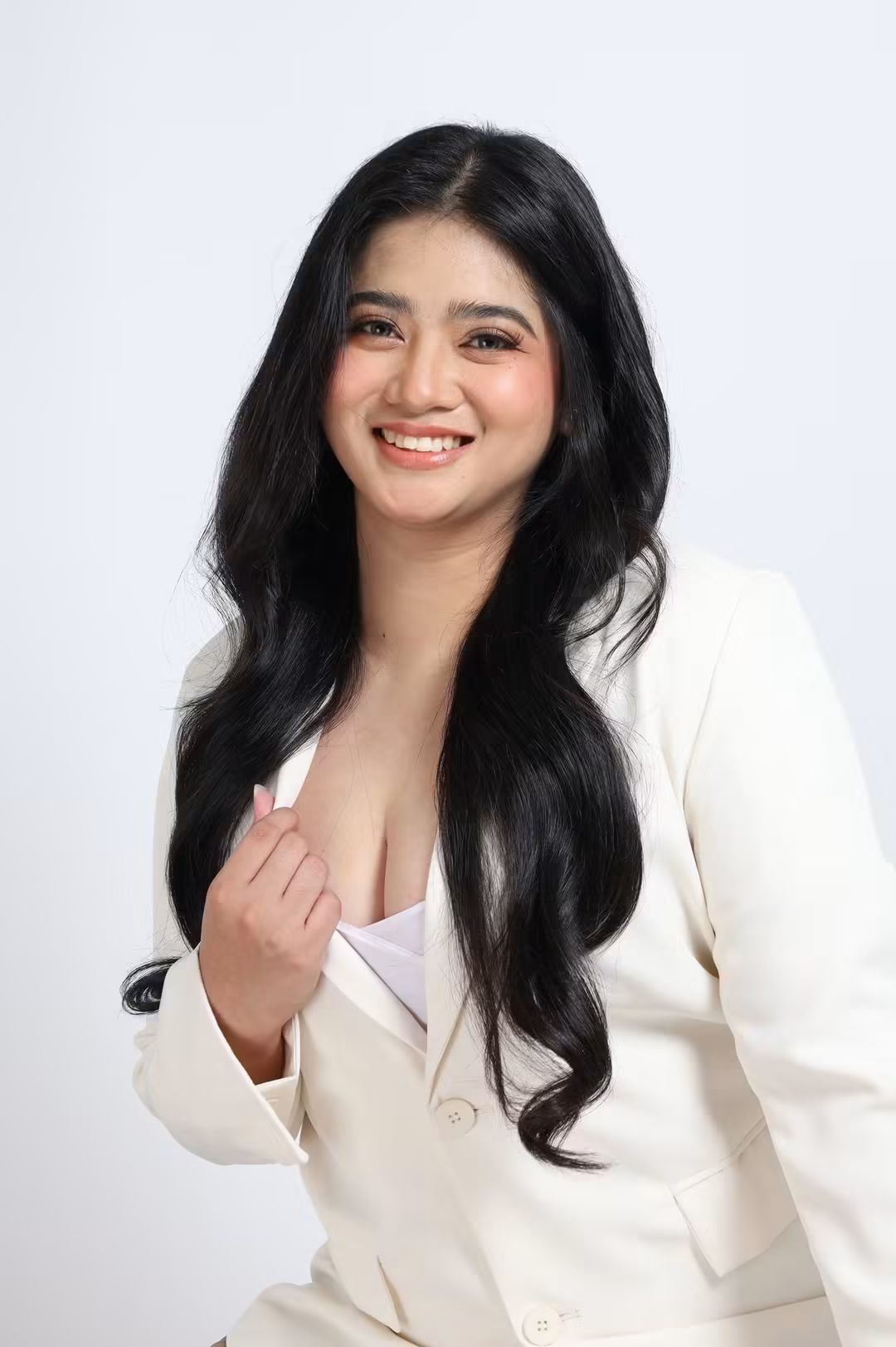 Tala smiling in a white blazer